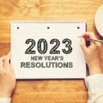 A notebook reads: 2023 New Year's Resolutions