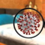 Magnifying glass looking at Coronavirus in bedroom