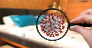 Magnifying glass looking at Coronavirus in bedroom