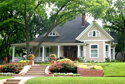 Front of a residential home with a walk up path of stairs and green grass