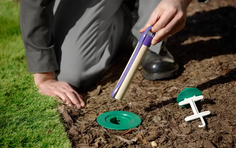 An Arrow Exterminating technician holding a Sentricon termite bait station